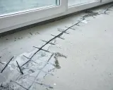 Betonboden mit eingeschnittenen Fugen und Bewehrung, bereit für die Ausbesserung des Estrichs.