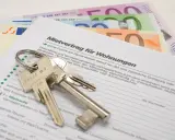 Schlüssel und Geld liegen auf einem Mietvertrag. Nach einer Privatinsolvenz kann dies ein Neuanfang für eine neue Wohnung sein, die Kaution ist gesichert.