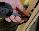 Hand connects a black Chromecast to a USB port on a device, preparing to chromecast mit wlan verbinden.