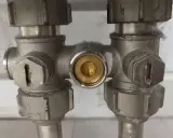 Detailaufnahme eines Einrohr-Hahnblocks. Die Funktionsweise wird durch die Ventile und den zentralen Anschluss verdeutlicht.
