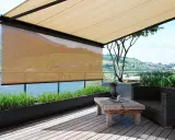 Terrasse mit Ausblick: Sonnenschutz-Markisen bieten Schatten. Ein rustikaler Tisch und ein Sessel laden zum Verweilen ein.