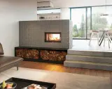 Ein moderner Kachelofen mit Feuerstelle und Holzvorrat. So funktioniert ein Kachelofen: Holz verbrennen, Wärme speichern, langsam abgeben.