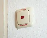 Ein beiger Schalter an einer weißen Wand mit der Aufschrift "Heizung" und "Notschalter". Dieser heizungsnotschalter pflicht ist wichtig für die Sicherheit.