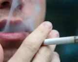 Nahaufnahme einer Person, die raucht. Der Rauch steigt auf und umhüllt die Lippen. Ein Fall von Mietminderung wegen Rauchgeruch.