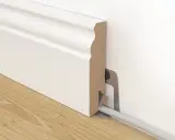 Weiße Sockelleiste mit Kabelkanal, die an der Wand befestigt ist. So kann man Leisten kleben und Kabel verstecken.