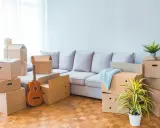 Umzugskartons stapeln sich, eine Gitarre lehnt an der Wand. Ein neuer Lebensabschnitt beginnt, ein Muster für den Einzug in die Mietwohnung.