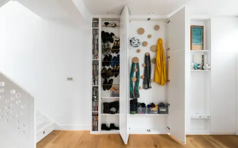 Praktisch den Eingangsbereich gestalten: Offene Schränke mit Schuhregalen, Garderobenhaken für Jacken und Schals, sowie dekorative Elemente.