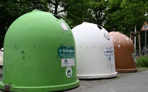 Drei Glascontainer in Grün, Weiß und Braun stehen nebeneinander. Hier kann man Fensterglas entsorgen.