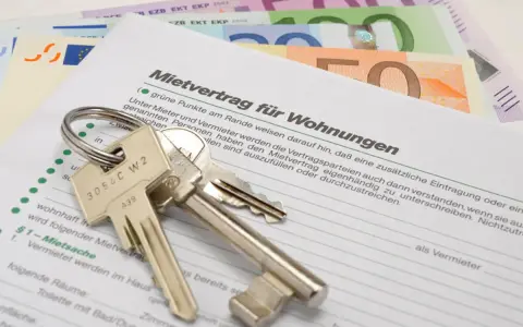 Schlüssel und Geld liegen auf einem Mietvertrag. Nach einer Privatinsolvenz kann dies ein Neuanfang für eine neue Wohnung sein, die Kaution ist gesichert.