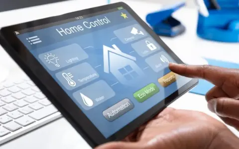 Ein Finger tippt auf ein Tablet mit der Home Control App. Hier kann man das smart home einrichten, Licht, Temperatur und mehr steuern.
