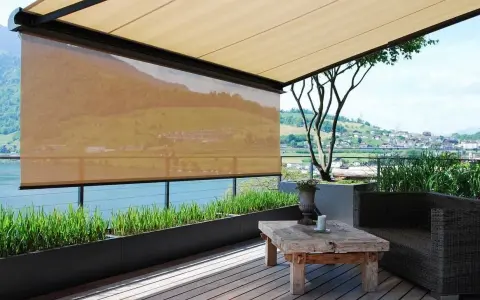 Terrasse mit Ausblick: Sonnenschutz-Markisen bieten Schatten. Ein rustikaler Tisch und ein Sessel laden zum Verweilen ein.