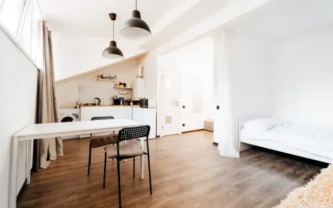 Helles, offenes Studio mit Küchenzeile, Essbereich und Bett. Perfekt für kleine Zimmer einrichten.