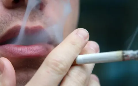 Nahaufnahme einer Person, die raucht. Der Rauch steigt auf und umhüllt die Lippen. Ein Fall von Mietminderung wegen Rauchgeruch.