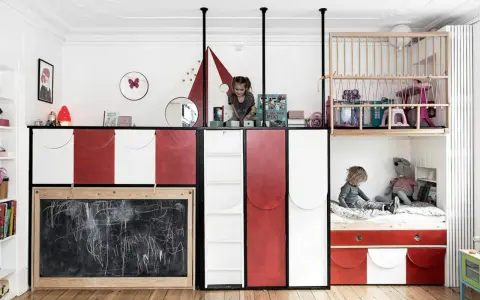 Kreatives Kinderzimmer mit wenig Platz: Zwei Kinder spielen auf verschiedenen Ebenen, eine Tafel und ein Hochbett mit Spielzeug.