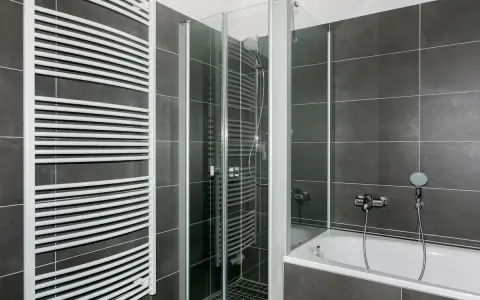 Modernes Bad mit Dusche und Wanne. Hier kann man sich nach einem langen Tag entspannen und ein kosten Vollbad genießen.