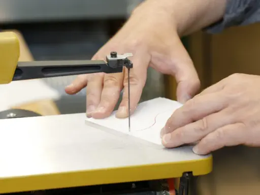 Präzises acrylglas schneiden mit einer Stichsäge. Hände führen das Material entlang der roten Schnittlinie.