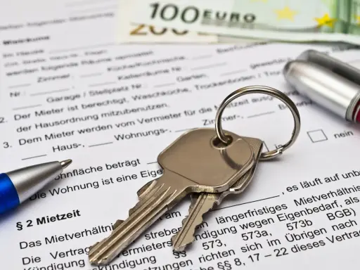 Schlüssel und Stift auf Mietvertrag. Ein Muster für die Erlaubnis zur Untervermietung kostenlos finden Sie hier.