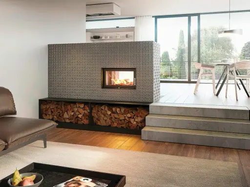 Ein moderner Kachelofen mit Feuerstelle und Holzvorrat. So funktioniert ein Kachelofen: Holz verbrennen, Wärme speichern, langsam abgeben.