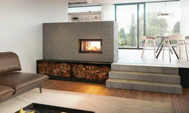 Ein moderner Kachelofen mit Feuerstelle und Holzvorrat. So funktioniert ein Kachelofen: Holz verbrennen, Wärme speichern, langsam abgeben.