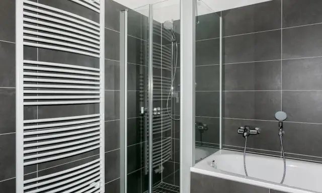 Modernes Bad mit Dusche und Wanne. Hier kann man sich nach einem langen Tag entspannen und ein kosten Vollbad genießen.