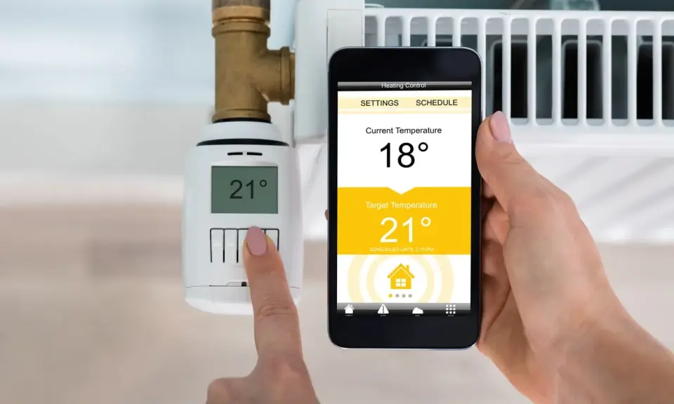 Heizung im Sommerbetrieb: Smartphone zeigt 18°C an, Zieltemperatur 21°C. Thermostat am Heizkörper zeigt 21°C.