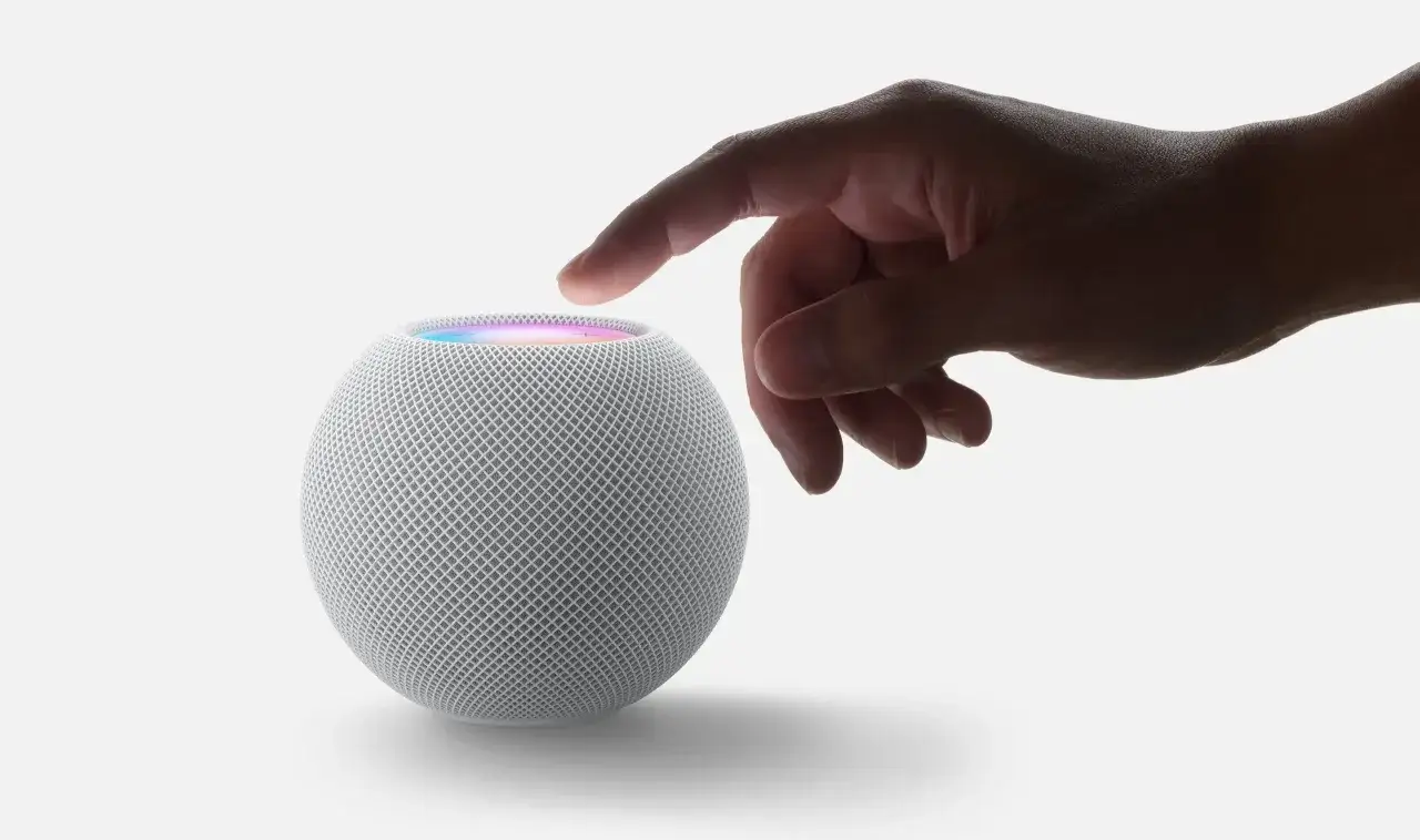 Ein Finger berührt den leuchtenden HomePod mini, bereit für die Steuerung von Smart-Home-Geräten mit Matter.
