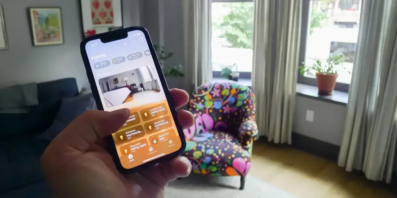 Hand h&auml;lt iPhone mit der Home App von Apple. Steuere dein Zuhause, Lichter und Kameras.