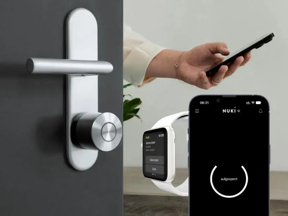 Moderner Türgriff mit Nuki Smart Lock. Eine Hand bedient ein Smartphone, das eine Apple Home Key-App zeigt.