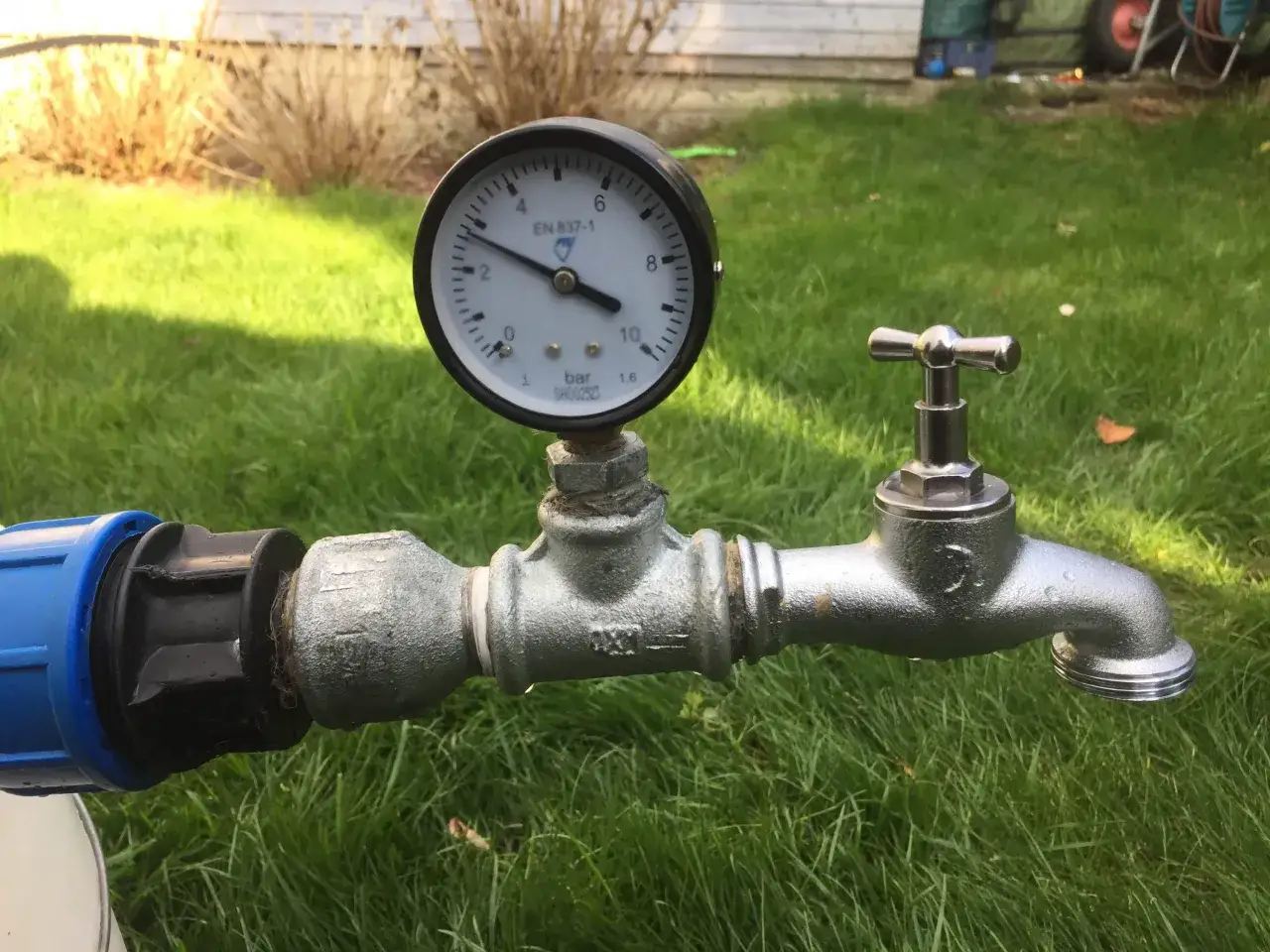 Manometer an einer Wasserleitung zeigt den Druck an. Der Wasserhahn ist bereit.