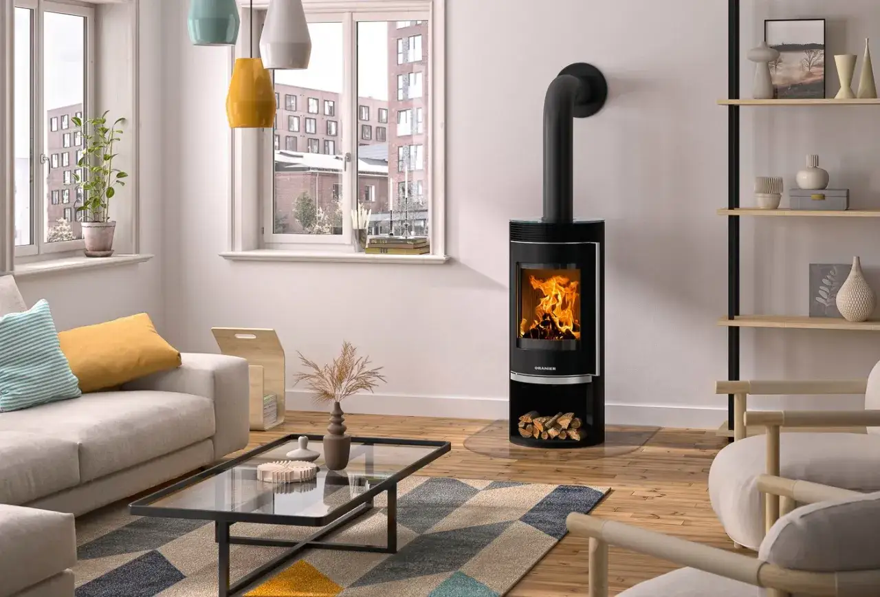 Moderner Kaminofen mit sichtbarem Feuer und Holzvorrat. Der Kaminofen steht sicher mit dem empfohlenen kaminofen abstand zur wand 10 cm.