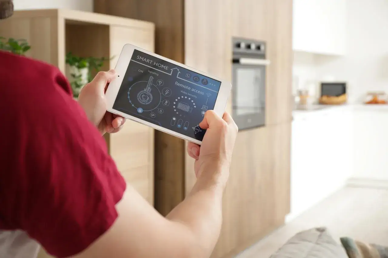 Mann richtet sein smart home ein und steuert die Videoüberwachung per Tablet.